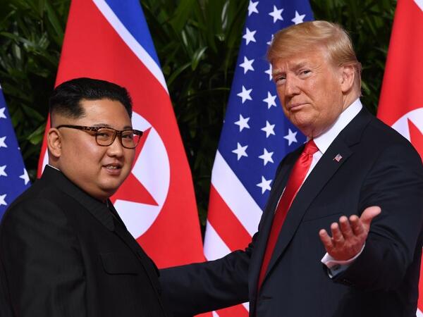 US President Donald Trump (R) gestures as he meets with North Korea's leader Kim Jong Un (L) at the start of their historic US-North Korea summit, at the Capella Hotel on Sentosa island in Singapore on June 12, 2018. (AFP/ File)