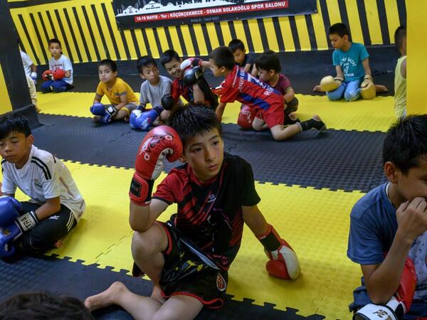 In this photograph taken on August 29, 2019, children from Muslim Uighur minority watch a Muay Thai training session in a boxing academy in Istanbul. BULENT KILIC / AFP