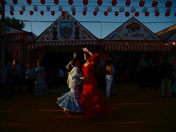 Women in traditional Sevillian dresses dance during the "Feria de Abril" (April Fair) festival in Seville on May 6, 2019.  AFP