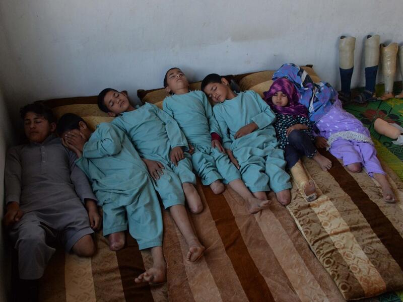 In this photograph taken on May 3, 2019, Hamisha Gul’s sons and grandchildren, who lost their legs following unexploded rocket explosion, rest in their bedroom in Khogyani district of Nangarhar province. NOORULLAH SHIRZADA / AFP