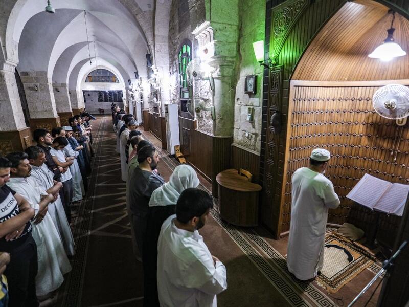 An imam leads Muslim worshippers in prayer at a mosque in Maaret al-Noman in Syria's northwestern Idlib province late on May 31, 2019, on the occasion of Lailat al-Qadr, which marks the night in the fasting month of Ramadan during which the Koran was first revealed to Prophet Mohammed in the seventh century.  OMAR HAJ KADOUR / AFP