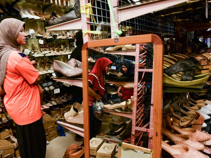 In this picture taken on June 1, 2019 Muslim women browse shoes in a store while shopping for Eid-al-Fitr, which marks the end of the holy month of Ramadan, in Narathiwat.  Madaree TOHLALA / AFP
