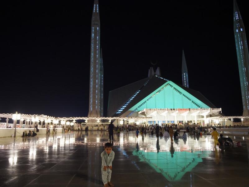 A child joins Pakistani Muslim worshippers and they gather at the illuminated Grand Faisal Mosque on the 27th night of the Holy month of Ramadan, in Islamabad on June 1, 2019.  The 27th night is known as Lailat al-Qader. FAROOQ NAEEM / AFP