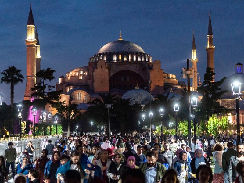 People stroll at the sunset in front of the Blue Mosque square during of the holy month of Ramadan on June 1, 2019 in Istanbul. The world's nearly 1.5 billion Muslims on May 27 began Ramadan, the holy month of dawn-to-dusk fasting and prayers. It is sacred to Muslims because tradition says the Koran was revealed to the Prophet Mohammed during that month. Yasin AKGUL / AFP