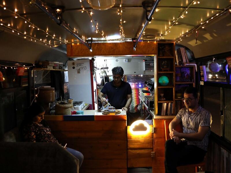 People have a drink at "The Bus Cafe Erbil" in Arbil, the capital of Iraq's Kurdish autonomous region, on June 7, 2019, on the long weekend of the Eid al-Fitr holiday which marks the end of the Muslim holy month of Ramadan.  SAFIN HAMED / AFP