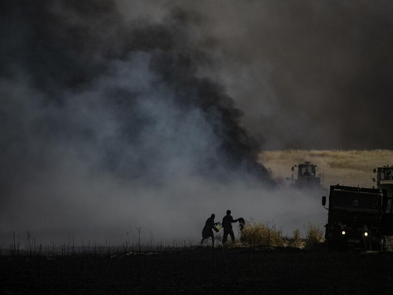 People battle a blaze next to an oil well in an agricultural field in the town of al-Qahtaniyah, in the Hasakeh province near the Syrian-Turkish border on June 10, 2019. Fires have erupted in various parts of Syria in recent weeks, with all sides blaming each other for starting them. Delil souleiman / AFP