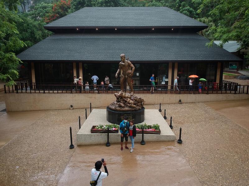 This aerial picture taken on June 15, 2019 shows visitors having their photo taken at the visitor centre for the Tham Luang cave, where 12 boys from the "Wild Boars" football team and their coach were trapped last year, in the Mae Sai district of Chiang Rai province. Lillian SUWANRUMPHA / AFP