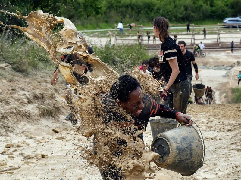 Mud is thrown at runners as they take part in the Mud Day, a 13km race with obstacles in Beynes, near Paris on June 16, 2019.  ALAIN JOCARD / AFP
