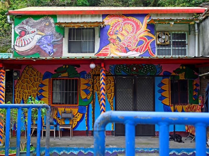 This picture taken on March 30, 2019 shows a dog sleeping in the courtyard of a house painted by Hakka graffiti artist Wu Tsun-hsien in the Taiwanese village of Ruan Chiao. Nestled in the mist-covered foothills of Taiwan's central mountain range, Ruan Chiao village is virtually devoid of young people, but artist Wu Tsun-hsien is coaxing the Instagram generation back by transforming local homes into a canvas of colour. Sam YEH / AFP