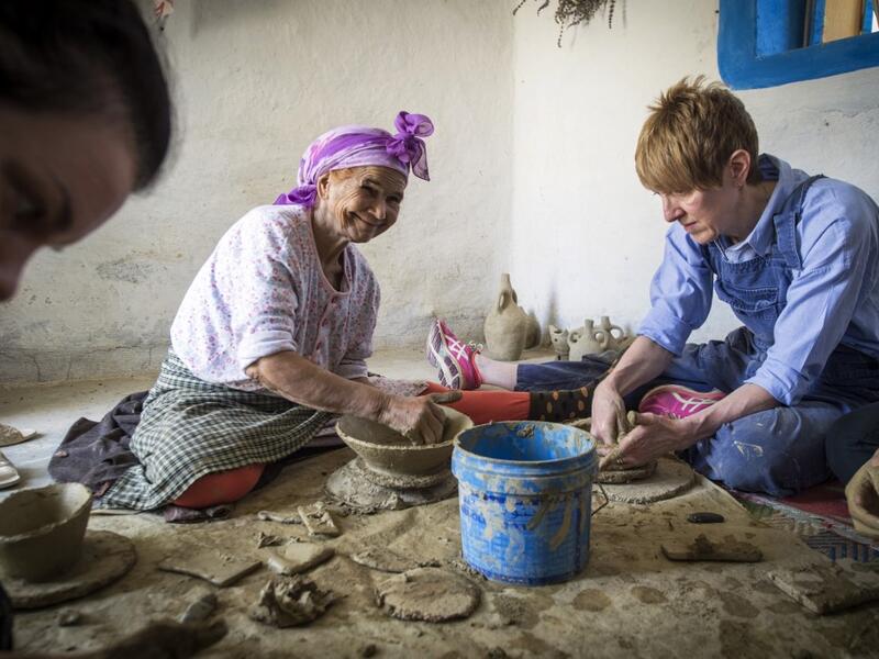 Moroccan potter Aicha Tabiz (L), also known as Mama Aicha, sits next to British apprentice Kim West (R), 33, during a pottery workshop near the village of Ourtzagh in the foothills of the Rif mountains on June 12, 2019. FADEL SENNA / AFP
