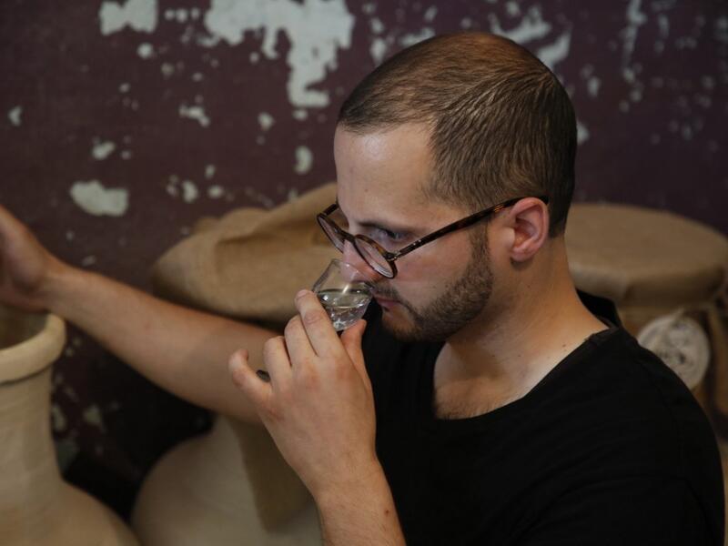 Palestinian distiller Nader Muaddi smells a glass of his Arak in the West Bank village of Beit Jala, near Bethlehem, on June 16, 2019. In his basement, distiller Muaddi made fewer than 500 bottles of liquor last year, but it is earning global acclaim and reviving interest in the Palestinian alcohol sector. On the outskirts of the city famed for Jesus's birth, the 35-year-old illustrates the handcrafted way he makes Arak, an anise-flavoured drink popular in the Middle East and similar to Greek Ouzo, French P