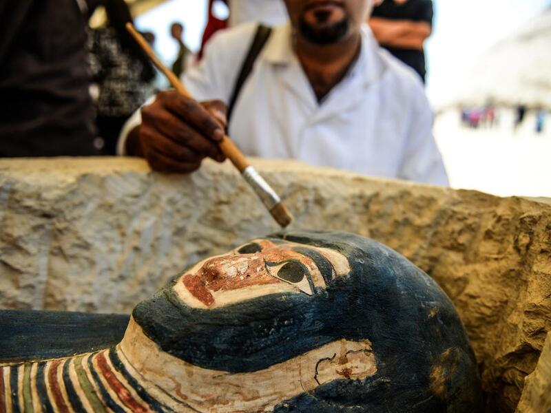 A man brushes off dust from a sarcophagus, part of a new discovery carried out almost 300 meters south of King Amenemhat II’s pyramid at Dahshur necropolis, exposed near the Bent Pyramid. Mohamed el-Shahed / AFP