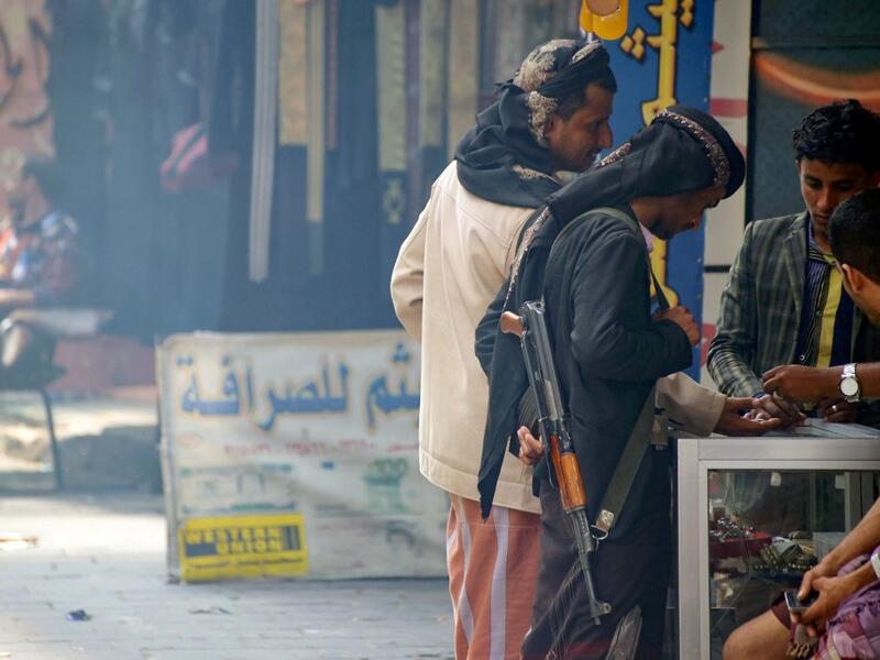 Armed men shop in Yemen's third city of Taez, on July 13, 2019. Before the war, the old market of Taez was crowded with people and full of handcrafts and artisanal goods. AHMAD AL-BASHA / AFP