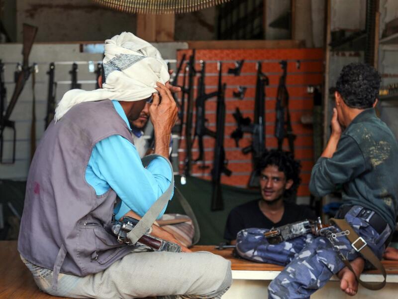 Armed men shop in Yemen's third city of Taez, on July 13, 2019. Before the war, the old market of Taez was crowded with people and full of handcrafts and artisanal goods. Today, more than four years after the Huthi rebels began their siege on Yemen's third largest city, bullets and guns have taken over the market. AHMAD AL-BASHA / AFP