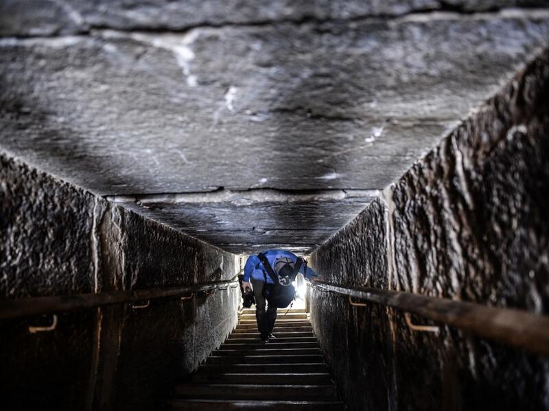 A man walks through a passage in the well-known bent pyramid of King Snefru, which had been closed to visitors since 1965, in Dahshur, some 30 kilometres (20 miles) south of Cairo, on July 13, 2019, after it was reopened by the Egyptian Antiquities Minister. Mohamed el-Shahed / AFP