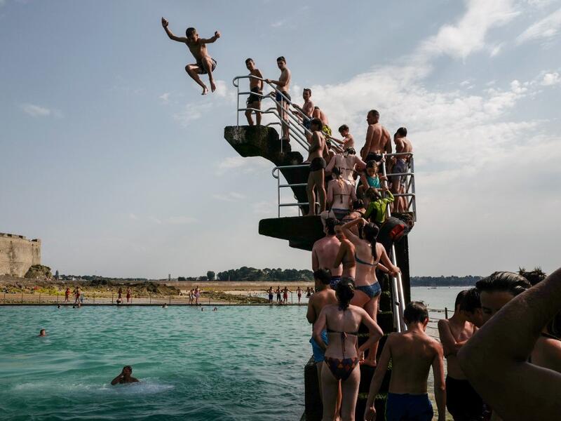 People queue to dive into the landmark sea pool of Saint-Malo, Brittany, on July 23, 2019 as a new heatwave blasted into northern Europe that could set records in several countries. Valery HACHE / AFP