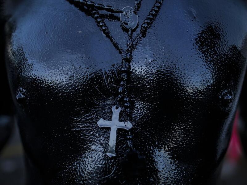 A catholic faithful smeared in burnt oil, takes part in the opening of the ten-day celebration of the Santo Domingo de Guzman festival in Managua, on August 1, 2019.  INTI OCON / AFP