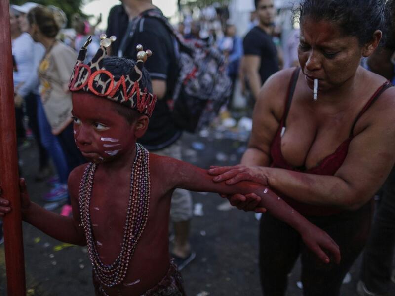 A catholic faithful woman paints her son with floor painture during the opening of the ten-day celebration of the Santo Domingo de Guzman festival in Managua, on August 1, 2019.  INTI OCON / AFP
