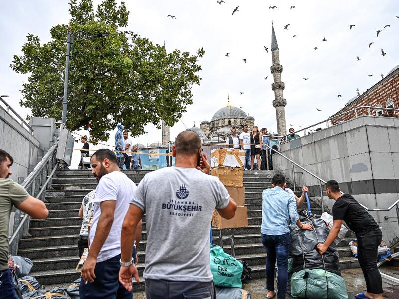 Shop owners try to save their belongings in a flooded undergate shop center in Eminonu district, Istanbul, after a heavy rainfall, on August 17, 2019. Turkey's mega city Istanbul was lashed by a heavy rainstorm on August 17, killing a homeless man and leaving parts of the historic Grand Bazaar flooded.  Ozan KOSE / AFP