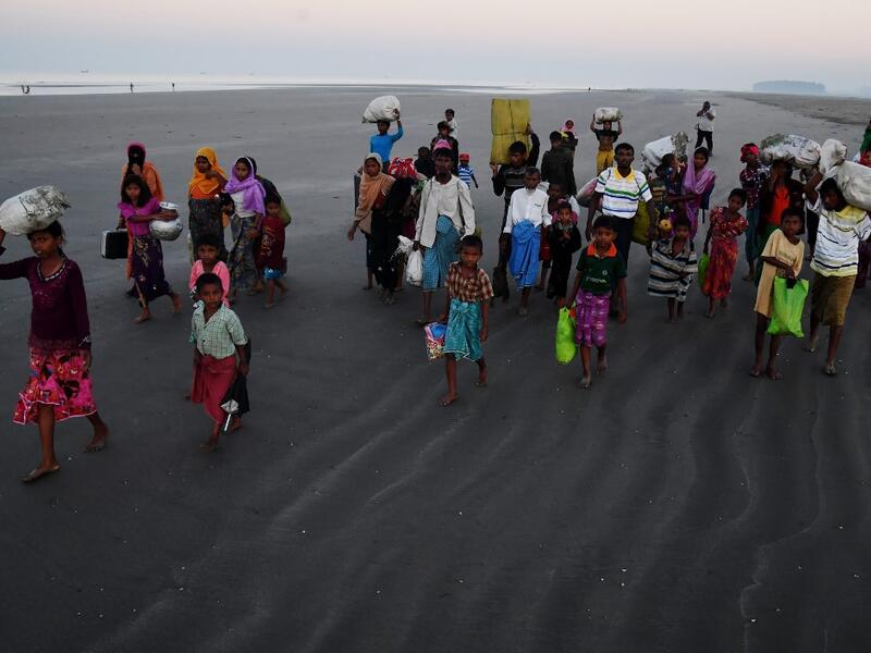 Rohingya Muslim refugees who entered Bangladesh by boat walk towards refugee camps after landing at the Saplapur beach in the Teknaf district. When hundreds of thousands of Rohingya fled Myanmar into Bangladesh two years ago. Dibyangshu SARKAR / AFP