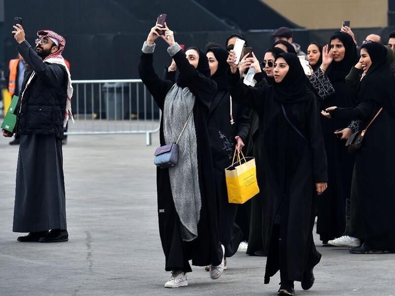 Saudi women take photographs with their mobile phones pior to the 2018 Saudia Ad Diriyah E-Prix Formula E Championship in Riyadh. (AFP /FAYEZ NURELDINE)
