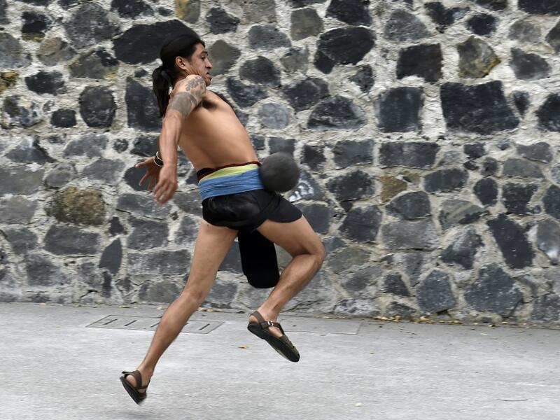 A man plays a pre-Columbian ballgame called "Ulama" -in Nahuatl indigenous language- which rule is to hit a "Ulamaloni" (solid rubber ball) with the hip or shoulder, during a match at the FARO Poniente cultural center in Mexico City on August 21, 2019. ROCIO VAZQUEZ / AFP