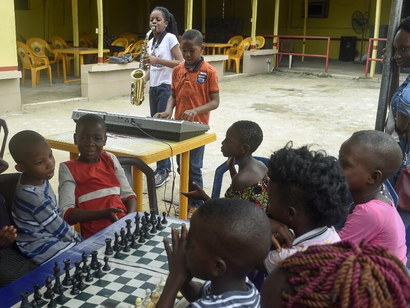 Young saxophonist Temilayo Abodurin (L) and pianist Joshua Akinotan play to motivate fellow children during a chess class at Ogolonto in Ikorodu district of Lagos, on August 17, 2019.  PIUS UTOMI EKPEI / AFP