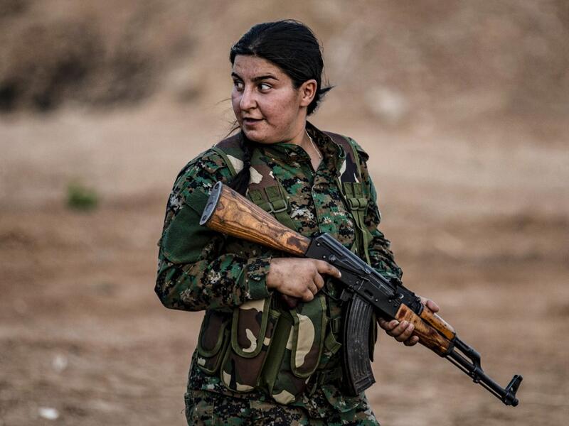 A member of the Bethnahrin Women Protection Forces (HSNB), an all-female Syriac-Assyrian paramilitary group under the umbrella of the Syrian Democratic Forces (SDF), lines up as the group commemorates the fourth anniversary of its creation, in the countryside of the town of Tall Tamr in the northwestern Syrian province of Hasakah, on August 30, 2019.  Delil SOULEIMAN / AFP