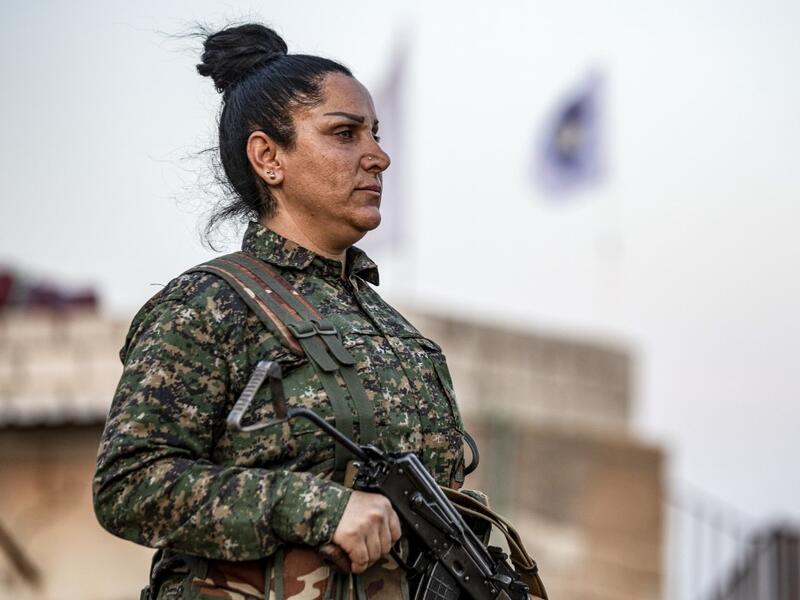 A member of the Bethnahrin Women Protection Forces (HSNB), an all-female Syriac-Assyrian paramilitary group under the umbrella of the Syrian Democratic Forces (SDF), lines up as the group commemorates the fourth anniversary of its creation, in the countryside of the town of Tall Tamr in the northwestern Syrian province of Hasakah, on August 30, 2019.  Delil SOULEIMAN / AFP