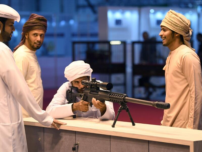 A visitor inspects a sniper rifle during the Abu Dhabi International Hunting and Equestrian exhibition (ADIHEX) in the UAE capital Abu Dhabi on August 31, 2019.  KARIM SAHIB / AFP