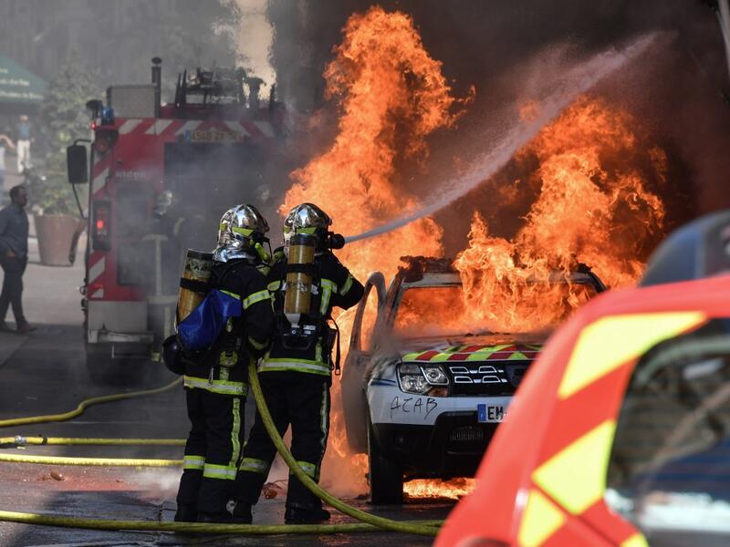 French firefighters spray water to extinguish a burning French Municipal Police car on the sidelines of an anti-government demonstration called by the "Yellow Vests" (Gilets Jaunes) movement in Montpellier, southern France on September 7, 2019. Pascal GUYOT / AFP