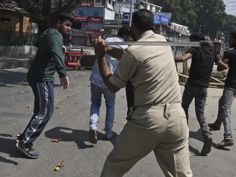 An Indian policeman clashes with Indian Kashmiri Shiite during a strict curfew in Lal Chowk area of Srinagar (AFP) An Indian policeman clashes with Indian Kashmiri Shiite during a strict curfew in Lal Chowk area of Srinagar (AFP)