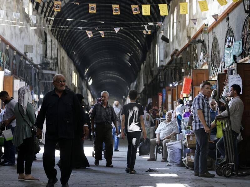 Shoppers walk through the Bzourieh market in the centre of the Syrian capital Damascus. LOUAI BESHARA / AFP