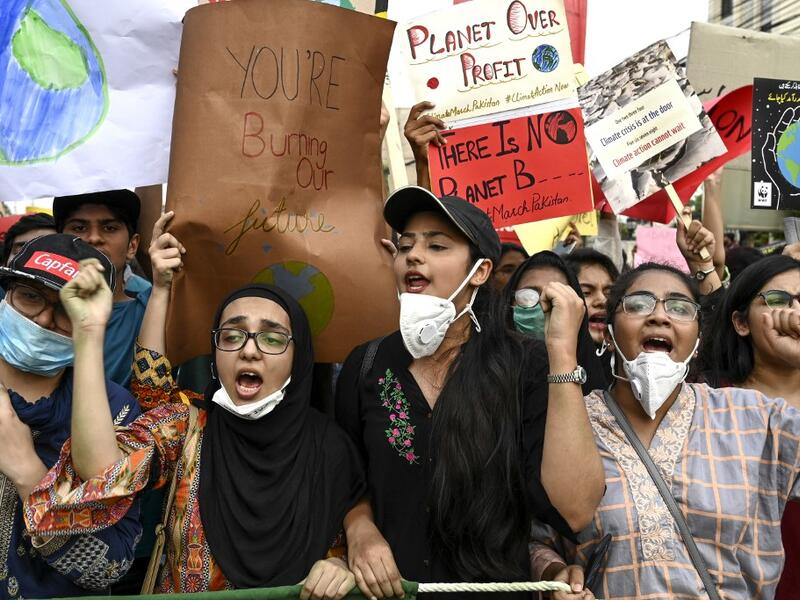 Youths hold placards as they march for a climate strike to protest against governmental inaction towards climate breakdown and environmental pollution, part of demonstrations being held worldwide in a movement dubbed "Fridays for Future", in Lahore on September 20, 2019. ARIF ALI / AFP