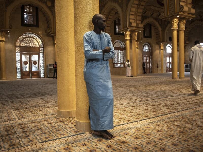 A worshipper stands inside the Great Mosque of the Mourides on September 27, 2019 in Dakar, ahead of its inauguration. Senegal's influential Mouride Brotherhood will inaugurate a 30,000-capacity mosque in the capital Dakar, said to be the largest in West Africa. JOHN WESSELS / AFP