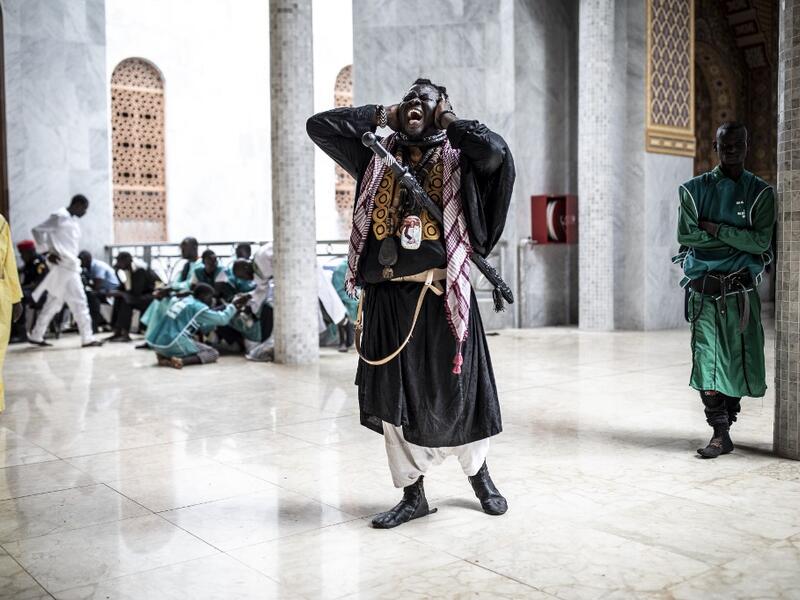 A Baye Fall disciple chants after entering the Great Mosque of the Mourides on September 27, 2019 in Dakar, ahead of its inauguration. Senegal's influential Mouride Brotherhood will inaugurate a 30,000-capacity mosque in the capital Dakar, said to be the largest in West Africa. JOHN WESSELS / AFP