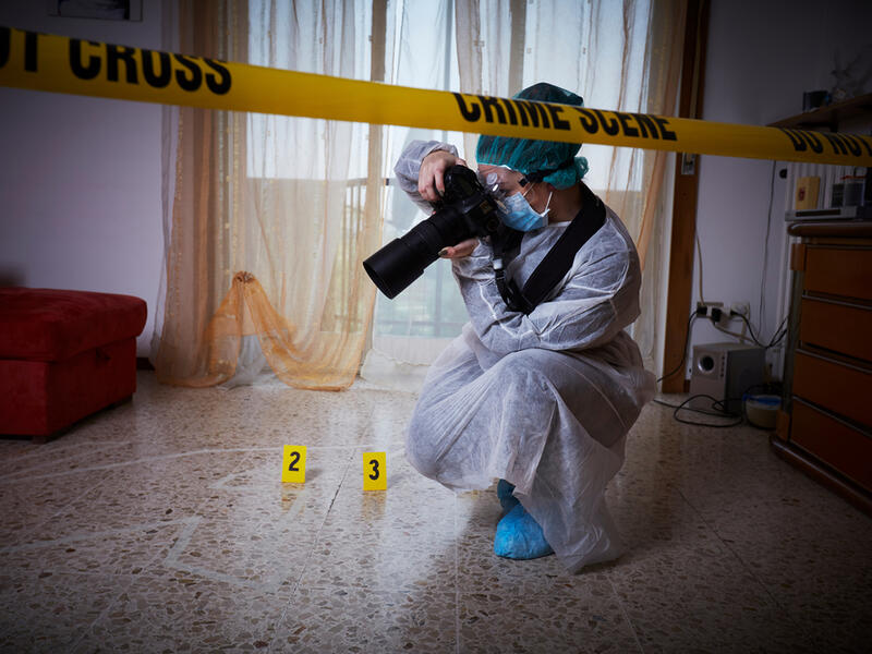 Forensics researcher photographing a blood at a murder scene. (Shutterstock/ File Photo)