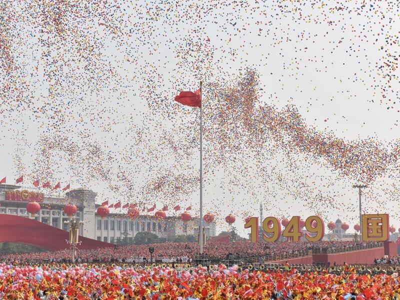 Balloons fly past the national flag at the end of a military parade at Tiananmen Square in Beijing on October 1, 2019, to mark the 70th anniversary of the founding of the People's Republic of China. GREG BAKER / AFP