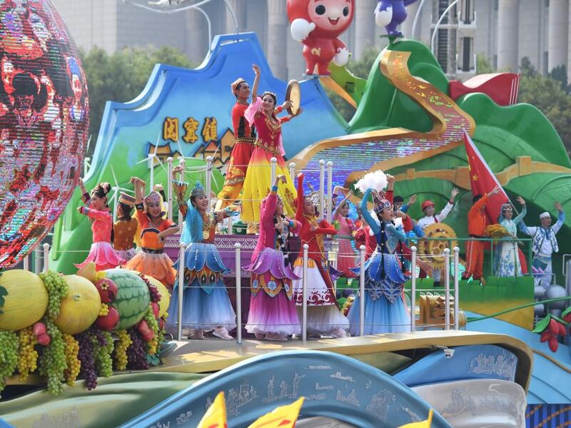 Performers stand on the Xinjiang region float as it passes by Tiananmen Square during the National Day parade in Beijing on October 1, 2019, to mark the 70th anniversary of the founding of the People's Republic of China. GREG BAKER / AFP