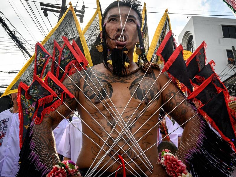A devotee of a Chinese shrine with multiple needles pierced through his cheeks takes part in a procession during the annual Vegetarian Festival in Phuket on October 4, 2019. Mladen ANTONOV / AFP