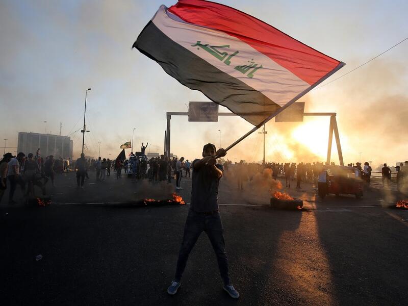 An Iraqi protester waves the national flag during a demonstration against state corruption, failing public services, and unemployment, in the Iraqi capital Baghdad on October 5, 2019. (AFP/ File Photo)