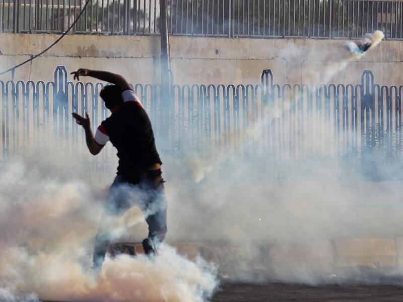 An Iraqi demonstrator gestures amidst smoke from burning tyres and tear gas during a demonstration against state corruption, failing public services and unemployment, in the Iraqi capital Baghdad on October 5, 2019. (AFP/ File Photo)