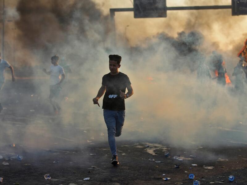 Iraqi demonstrators run amidst smoke from burning tyres during a demonstration against state corruption, failing public services, and unemployment, in the Iraqi capital Baghdad on October 5, 2019. (AFP/ File Photo)