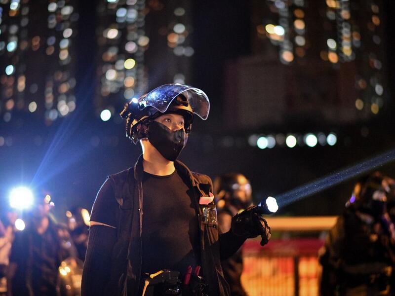 Riot police shine lights at protesters outside Ma On Shan police station in the New Territories of Hong Kong on October 9, 2019. (Anthony WALLACE / AFP)