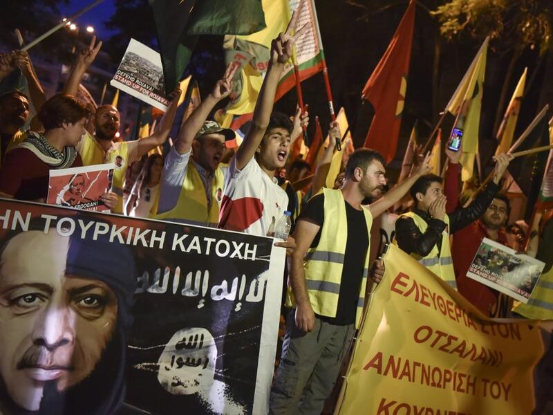Kurds living in Athens hold flags and banners as they protest near the Turkish embassy in Athens, on October 9, 2019. Turkey launched an assault on Kurdish forces in northern Syria with air strikes and explosions reported along the border. President Recep Tayyip Erdogan announced the start of the attack on Twitter, labelling it "Operation Peace Spring". Louisa GOULIAMAKI / AFP
