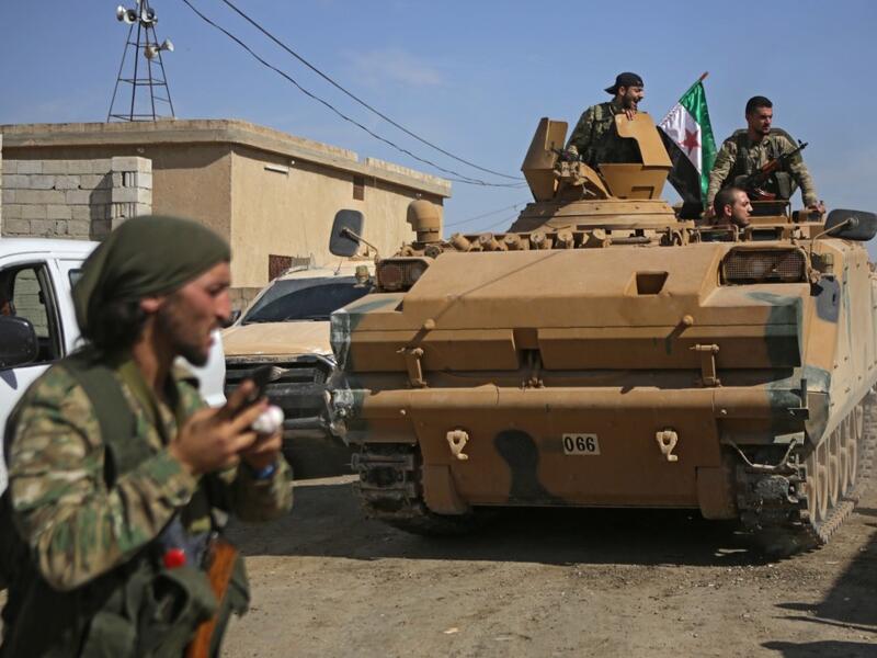 Turkish-baked Syrian fighters drive an armoured personnel carrier near the Syrian border town of Tal Abyad on October 12, 2019, as they prepare to take part in the Turkish-led assault on northeastern Syria. Bakr ALKASEM / AFP