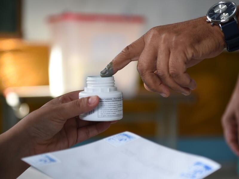 A Tunisian voter dips his finger in ink after casting his ballot at a polling station in the capital Tunis on October 13, 2019 during the second round of the presidential election. Tunisians began voting today in a presidential runoff pitting conservative law professor Kais Saied against media magnate Nabil Karoui, who was released from prison just days earlier. FETHI BELAID / AFP
