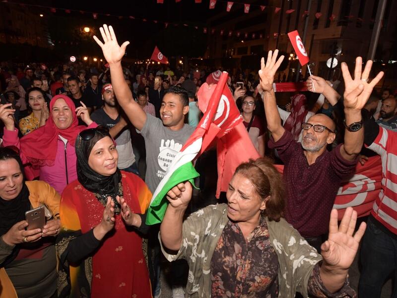 Tunisians gather to celebrate the victory of Kais Saied in the Tunisia's presidential runoff on October 13, 2019, in the capital Tunis. Conservative academic Kais Saied, a political outsider, won a landslide victory Sunday in Tunisia's presidential runoff, sweeping aside his rival, media magnate Nabil Karoui, state television said. Fethi Belaid / AFP