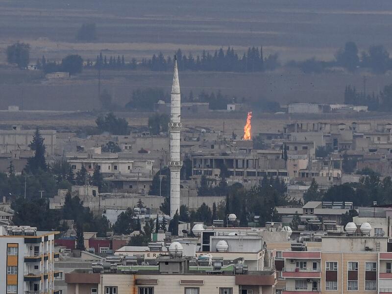 Turkish side of the border with Syria in the Ceylanpinar district city of Sanliurfa shows a fire rising from the Syrian town of Ras al-Ain (AFP)