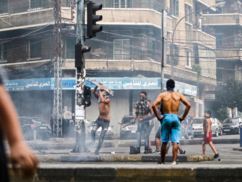 Lebanese demonstrators break traffic lights amidst ongoing protests against dire economic conditions in the northern coastal city of Tripoli on October 18, 2019. Ibrahim CHALHOUB / AFP